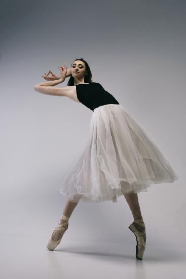Der Mut. eine junge Ballerina im schwarzen Rock und Chopin steht auf Spitzenschuhen