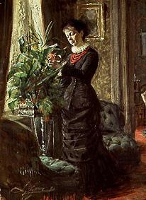 Frau Lisen Samson beim Arrangieren von Blumen vor einem Fenster von Anders Leonard Zorn