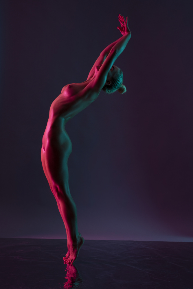 Junge nackte Frau tanzt vor dunkelviolettem Hintergrund von Andrey Guryanov