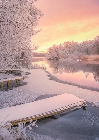 Gefrorener Steg und rosa Sonnenuntergang