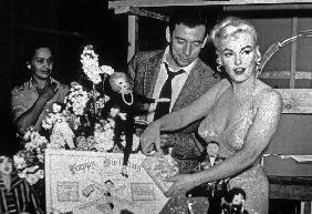 French Actor Yves Montand, American Actress Marilyn Monroe and a birthday cake.