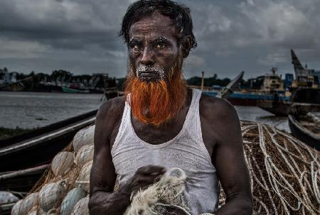 Ein Mann aus Bangladesch entwirrt Netze.
