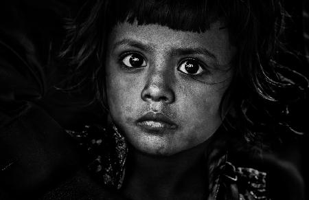 Kleines Mädchen auf dem Schoß ihres Vaters – Bangladesch