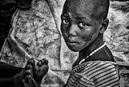 Mädchen aus dem Larim-Stamm massiert Füße – Südsudan