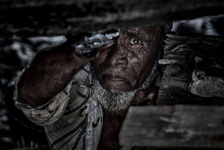 Mann,der den Kiel eines Schiffes teert – Bangladesch