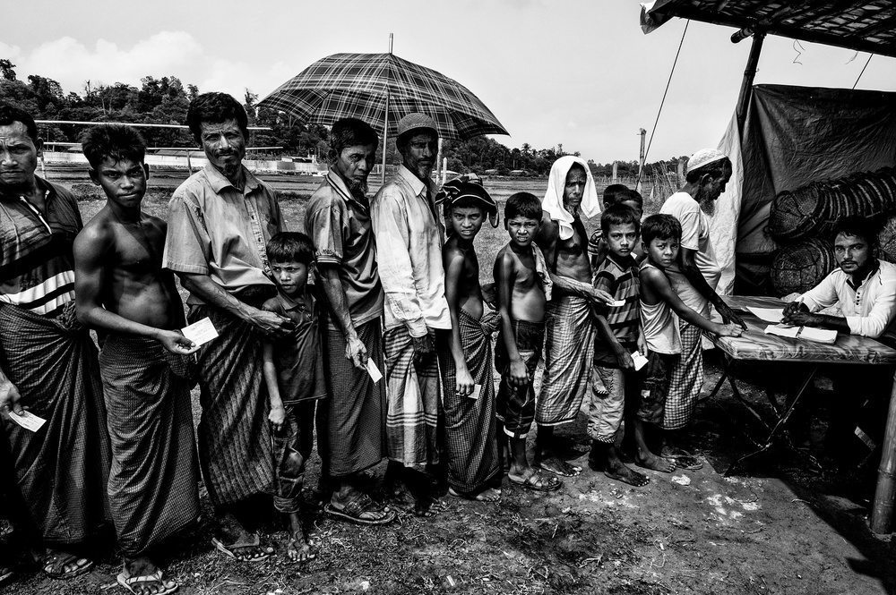 Rohingya-Flüchtlinge stehen Schlange,um einige Gegenstände für den Bau ihrer Häuser zu bekommen. von Joxe Inazio Kuesta Garmendia