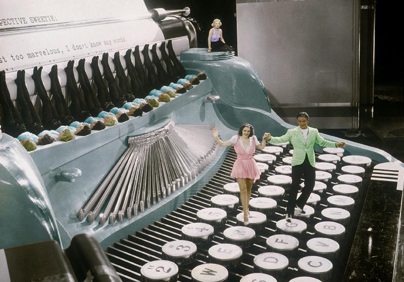 Couple dancing on the key of a giant typewriter, keys are leg of dancers, musical, 30's colourized d von 