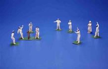Eleven German bisque figures of cricketers and an umpire (painted lead) 03rd-