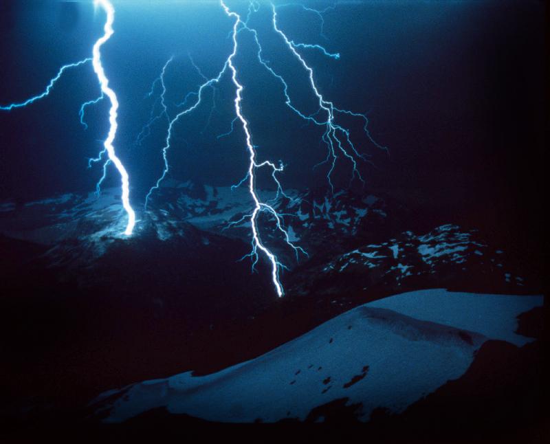 Lightning during a storm over snowy mountains von 
