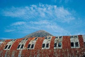 Rusted roof of a deserted warehouse with the breast of a mountain (photo) 