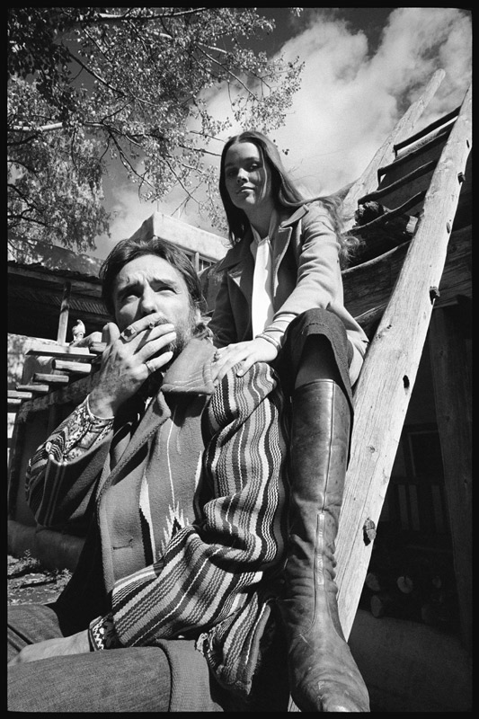 Dennis Hopper and wife Michelle Phillips on a ladder in New Mexico von Orlando Suero