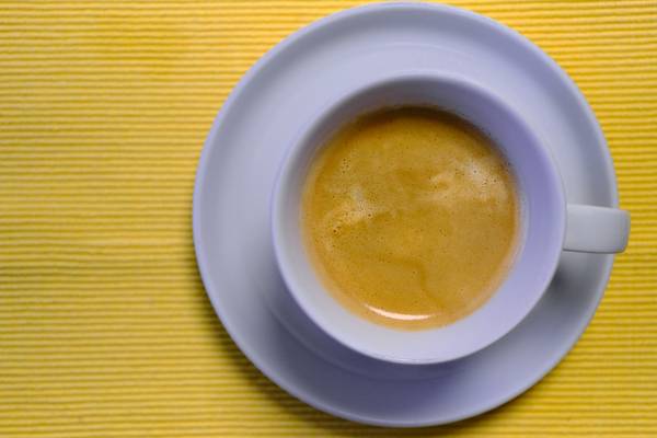 Kaffeetasse mit Kaffee auf gelbem Untergrund von Robert Kalb