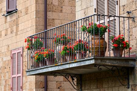 Romantischer Balkon mit roten Blumen in Tonkrügen 2016