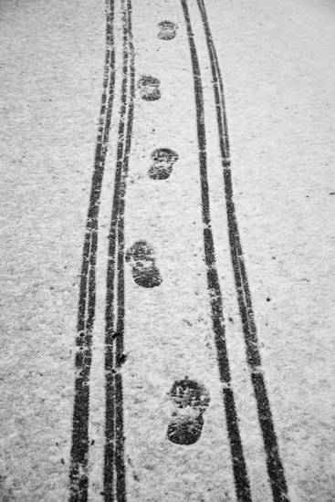 Verschiedene Reifenspuren und Fußspuren auf der Schneefahrbahn 2015