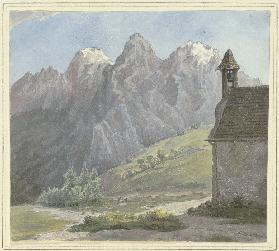 Berggipfel in den Alpen, vorne eine Kapelle