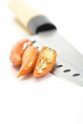 Gelbe Peperoni mit Messer von Thomas Haupt